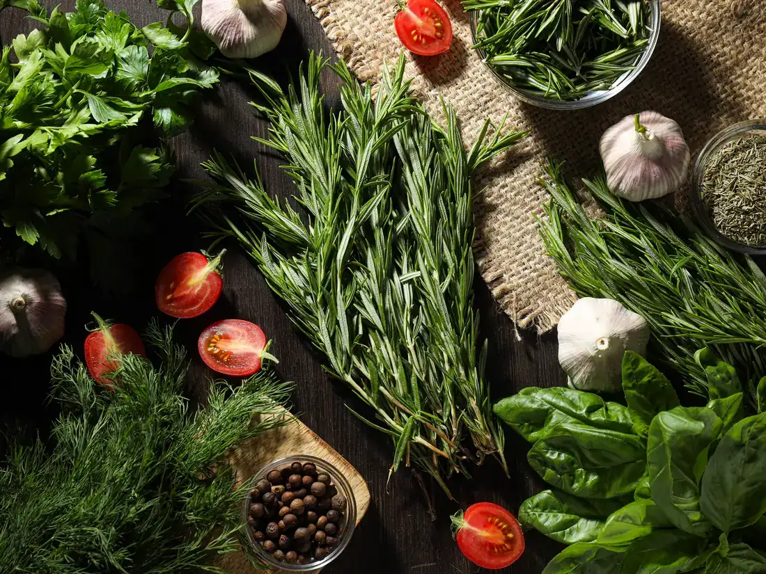 Fresh rosemary, parsley, dill, basil, garlic and cherry tomatoes ready for healthy cooking