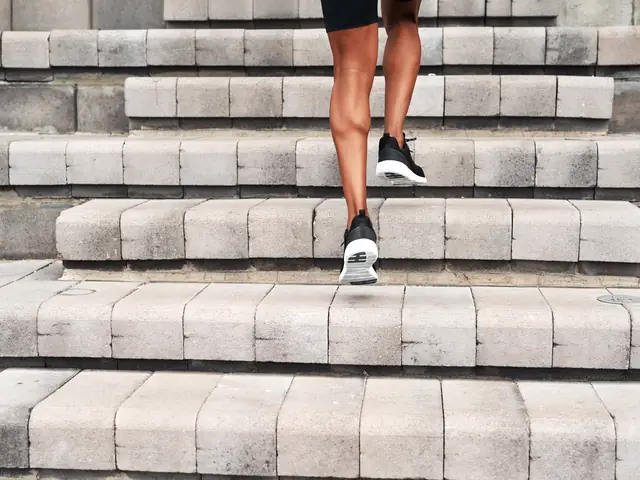 Person in athletic shoes walking up outdoor stone steps